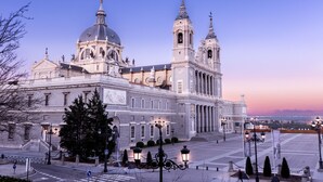 A grand historic building with a large dome, two bell towers, and a spacious plaza. - La Reina de Gran Via (Madrid)