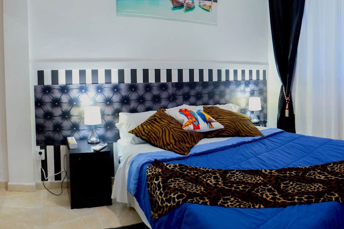 Ein Hotelzimmer mit Bett, Nachttisch, Stuhl und Tür.