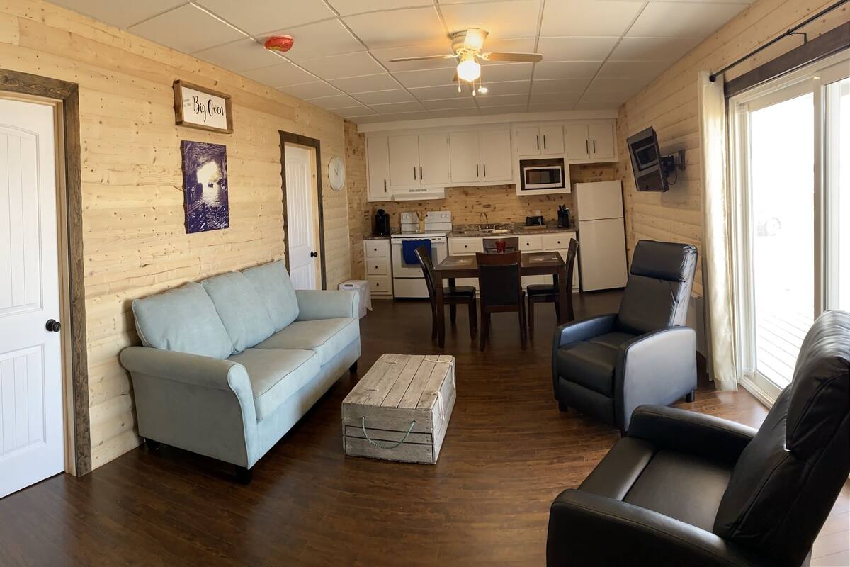 L’intérieur chaleureux d’un chalet en bois comprend un salon, un coin repas et une petite cuisine.
