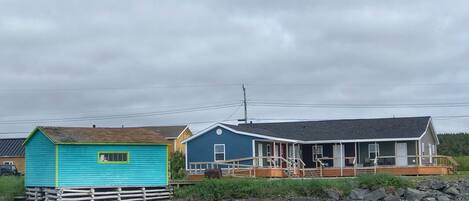 A row of waterfront cabins with a wooden dock in front.