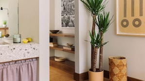 A kitchen with a terrazzo countertop, a potted plant, a woven basket, and a framed black and white photograph on the wall. - Silver Lake Pool & Inn (Los Angeles)