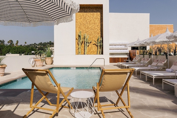Una piscina al aire libre, sombrillas, tumbonas