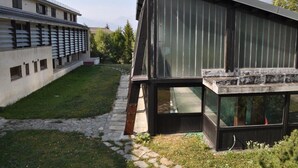 A modern building with large windows and a sloped roof. - Rustic in the Chapelle complex (Sauze d` Oulx)