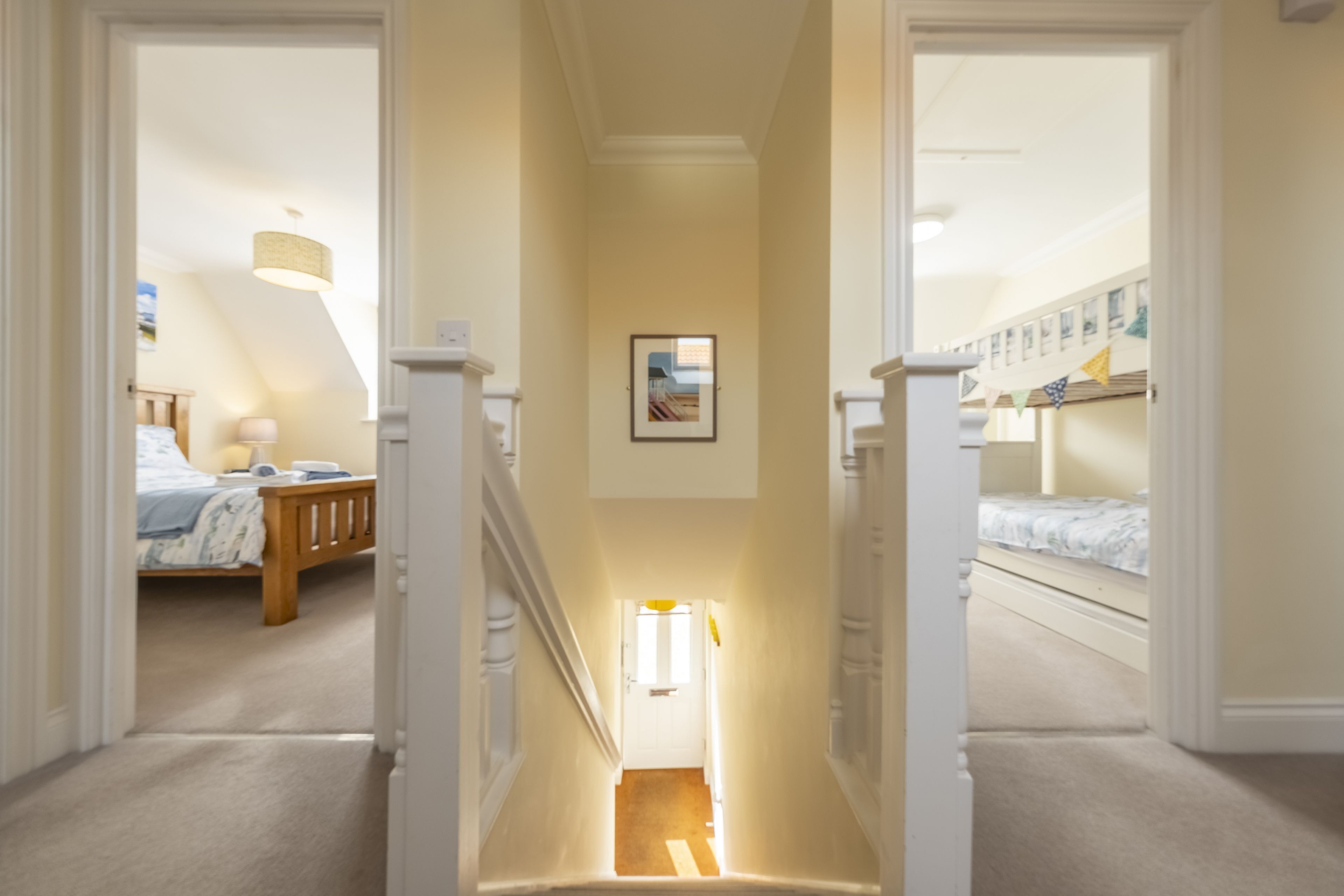 Un couloir avec un escalier menant à une chambre.