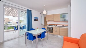 A modern kitchen with a gas stove, wooden cabinets, and a tiled backsplash. - Levante, Holiday Home 100 metres from the sandy beach and near the centre (Marina di Ragusa)