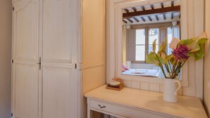 A room with a large white wardrobe, a vanity with a mirror, and a window with a view of buildings. - Beautiful apartment for 4 guests with WIFI, A/C, TV and pets allowed (Cortona)