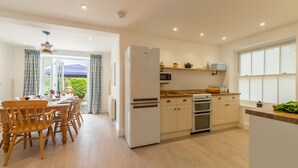 Eine moderne Küche mit Kühlschrank, Backofen, Mikrowelle und Holzarbeitsplatte.