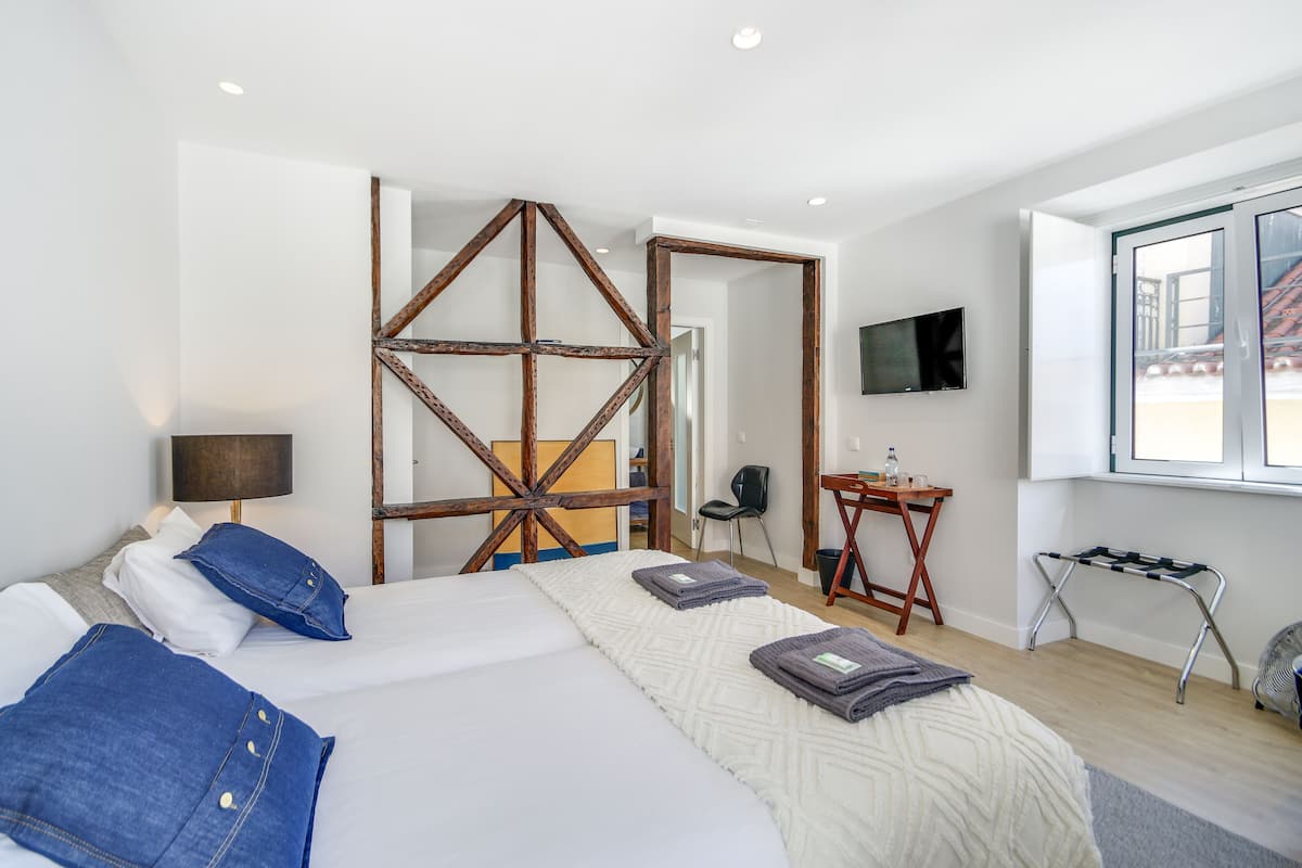 Una habitación de hotel con una cama, un escritorio, una silla, un televisor y una ventana.