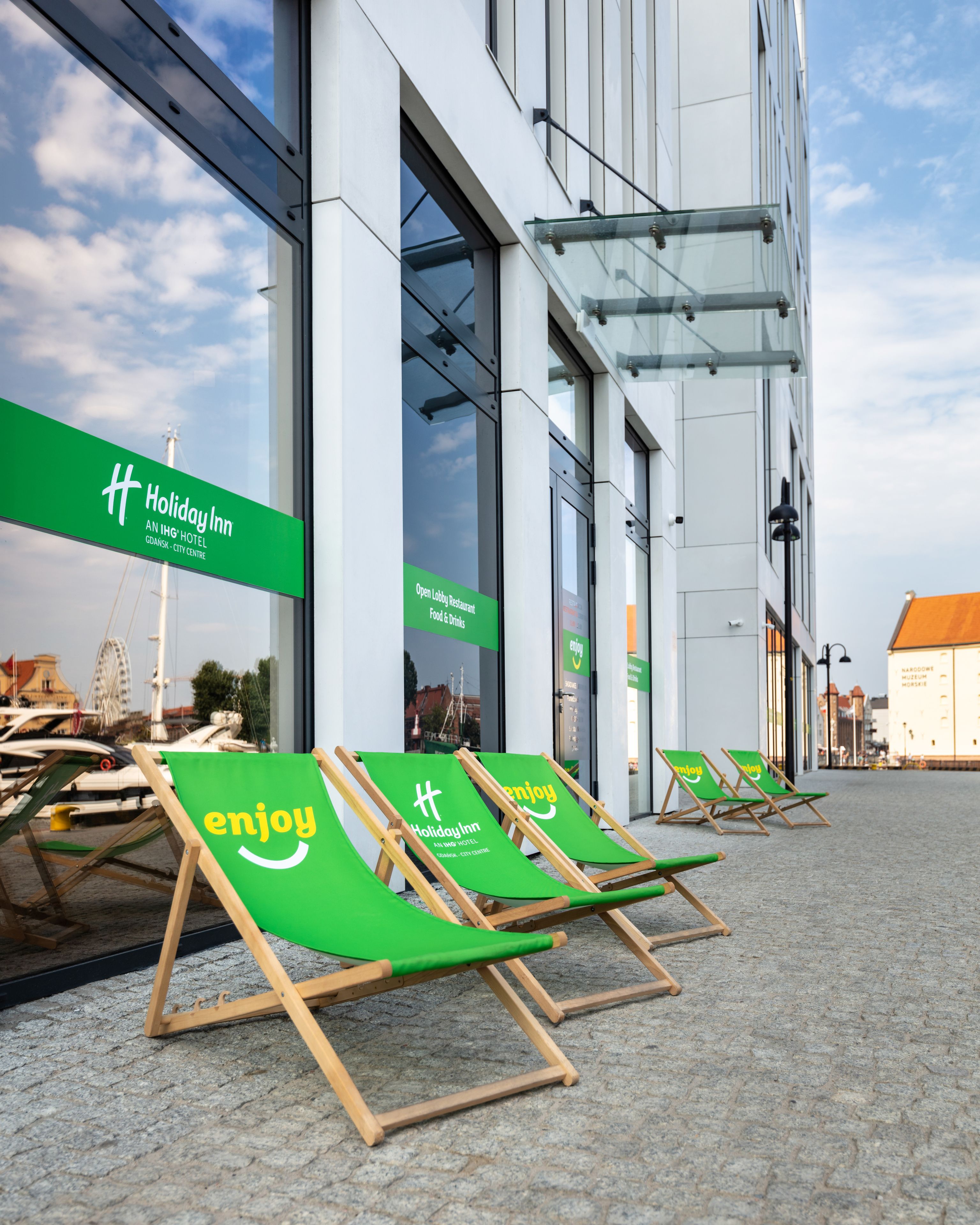 A Holiday Inn with outdoor seating and a view of the city center.