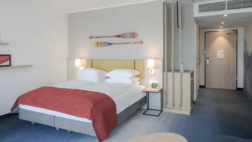 Une chambre d’hôtel comprenant un lit, des tables de chevet, un bureau et une chaise.