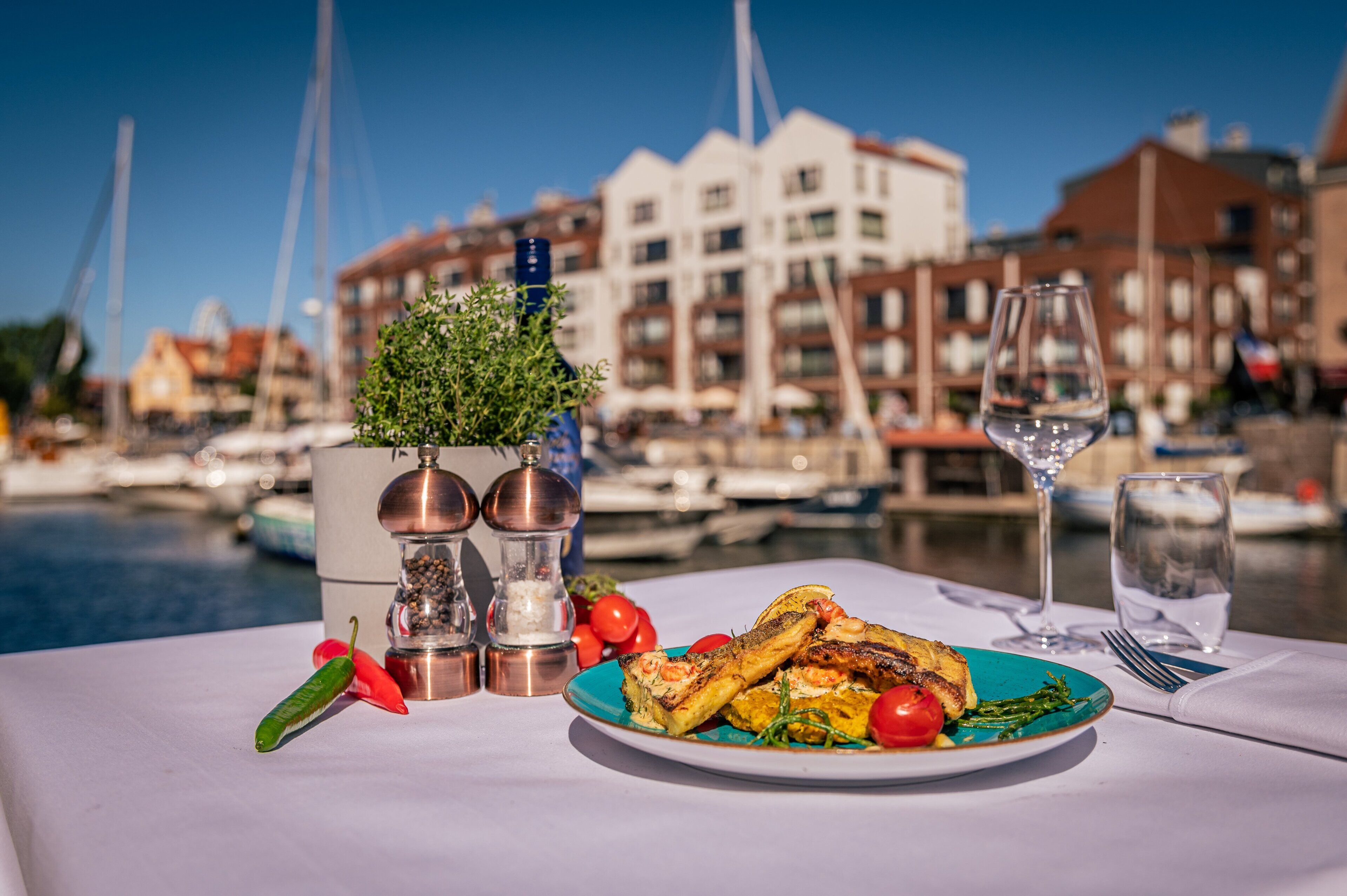 A table with a plate of food, a glass of water, and salt and pepper shakers.