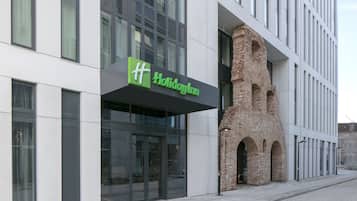 Un hotel Holiday Inn con fachada moderna, amplios ventanales y un característico arco de ladrillo.
