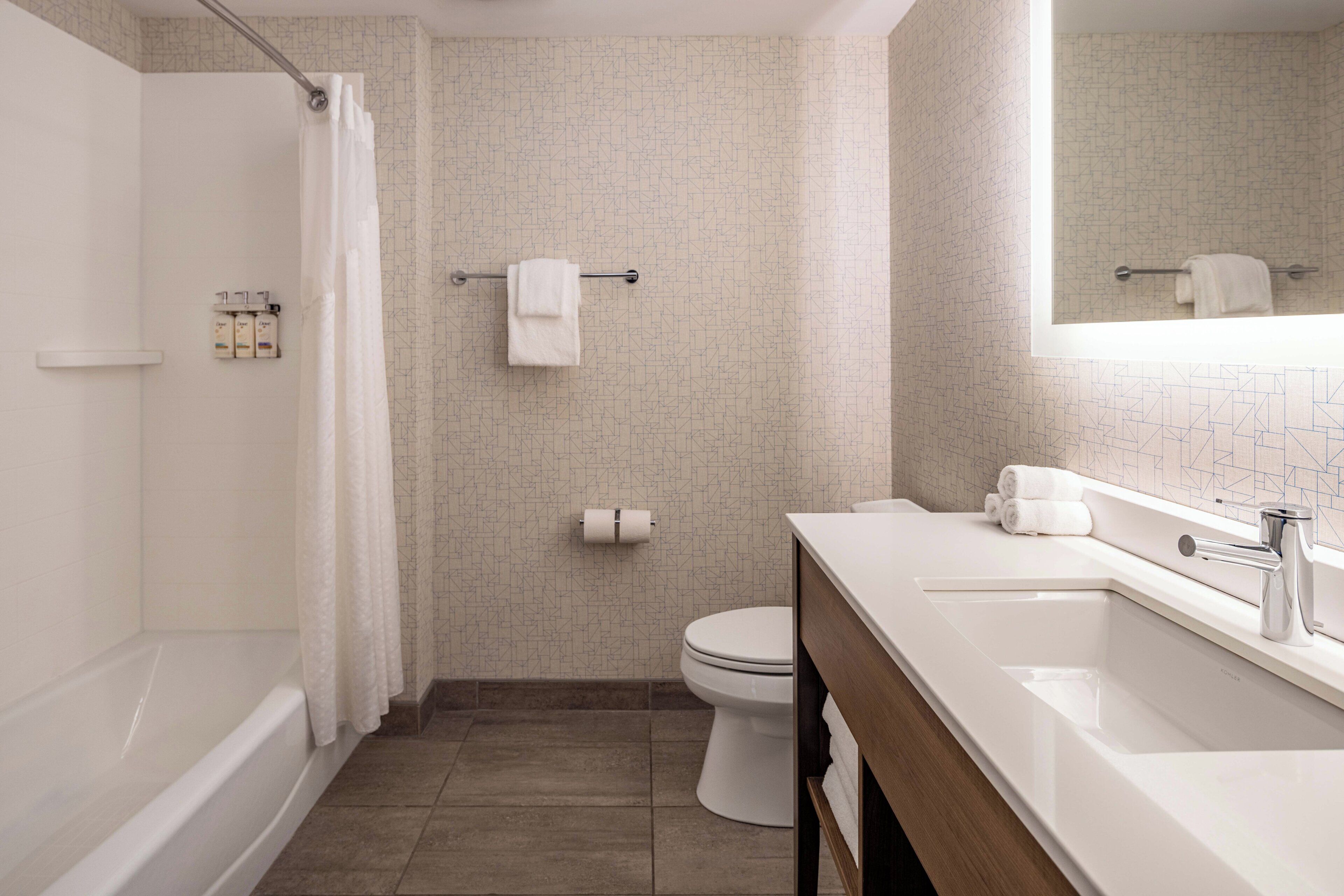 Un baño moderno con bañera, inodoro y lavamanos.
