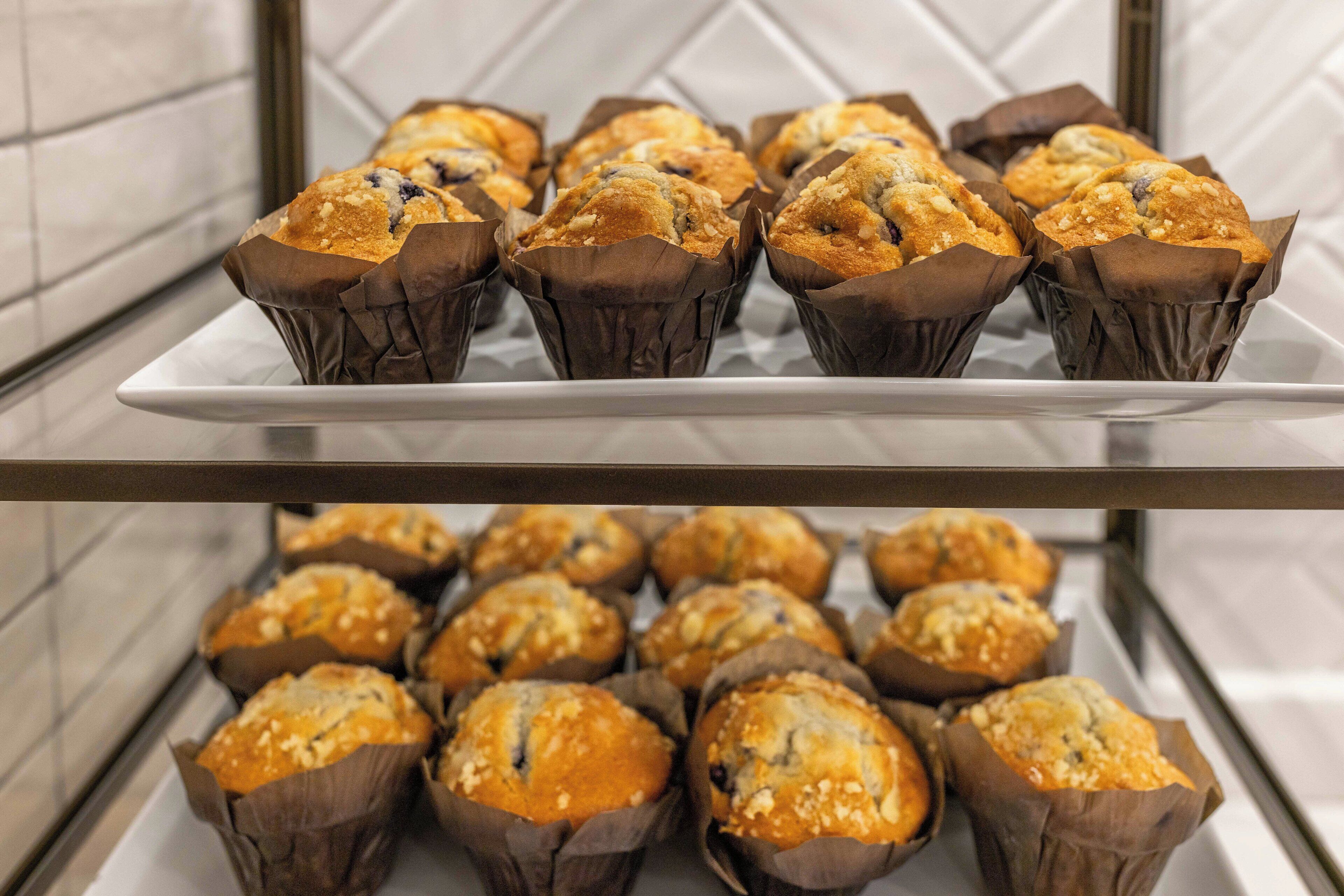 Una bandeja de muffins en vasos de papel marrón sobre un plato blanco.