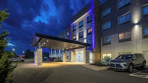 A hotel with a covered entrance, stone pillars, and a parked SUV. - Holiday Inn Express & Suites Halifax - Dartmouth by IHG (Dartmouth)