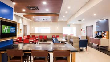 Relax in our spacious seating area with comfortable chairs and a communal table, featuring a flat-screen TV and a convenient coffee station.