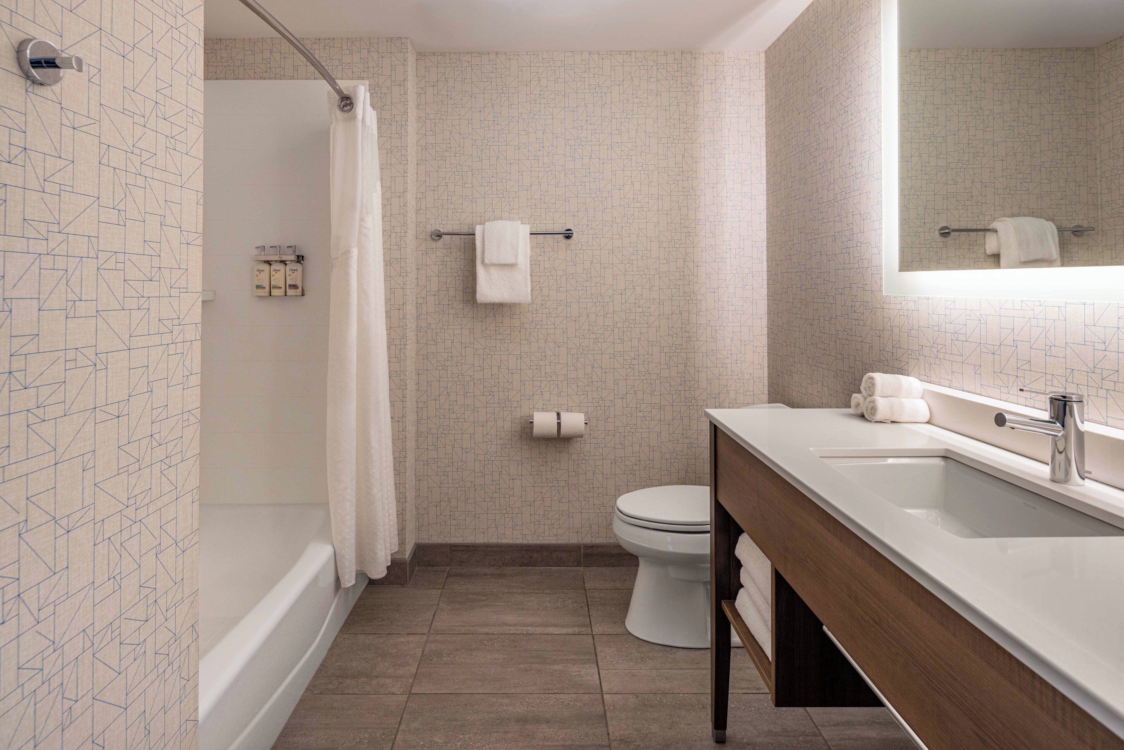 A modern bathroom with a bathtub, toilet, and sink.