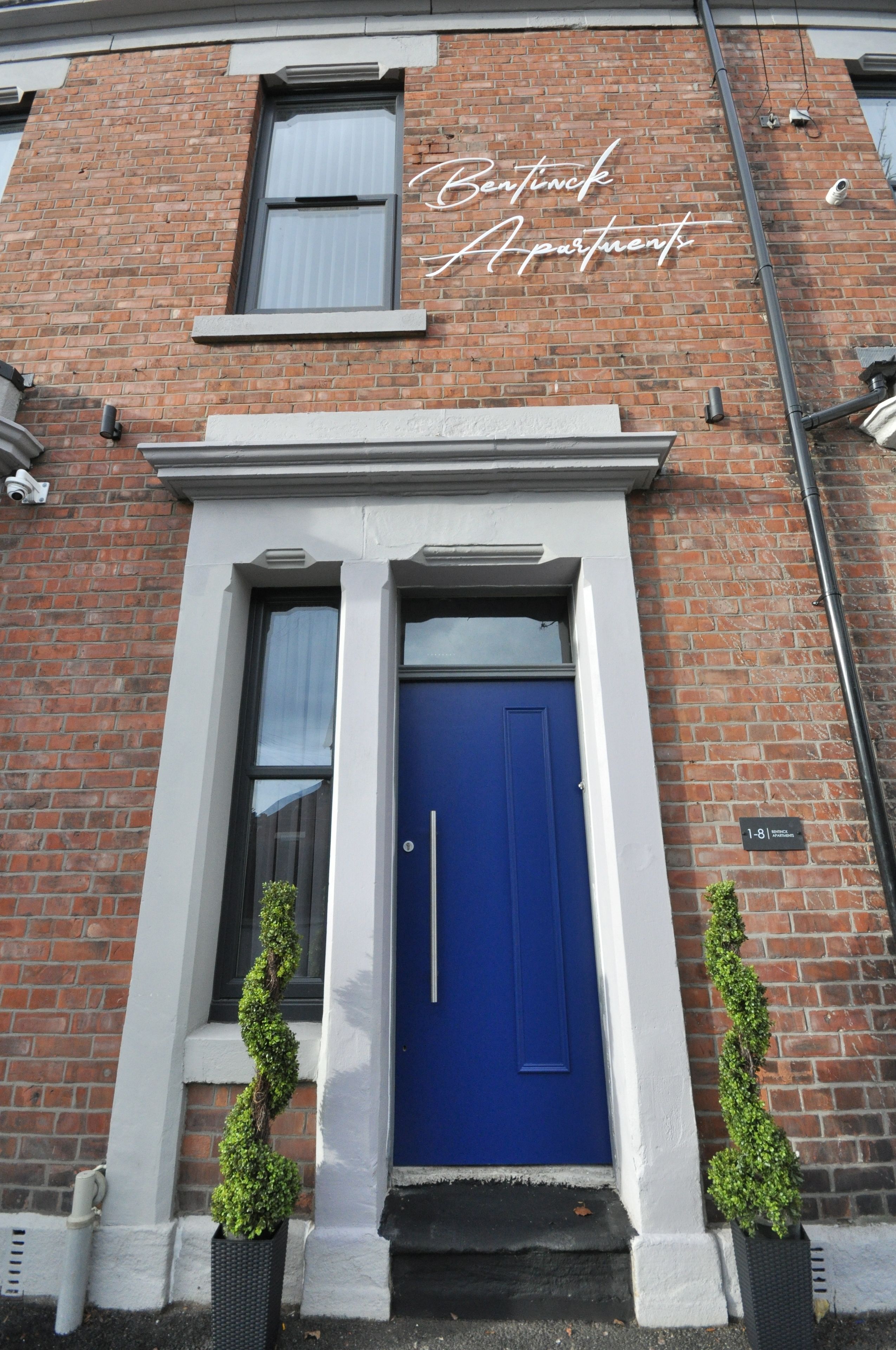A brick building with a blue door and white trim.