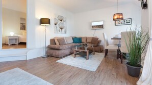 Un salon moderne avec un canapé, une table basse et une plante en pot.