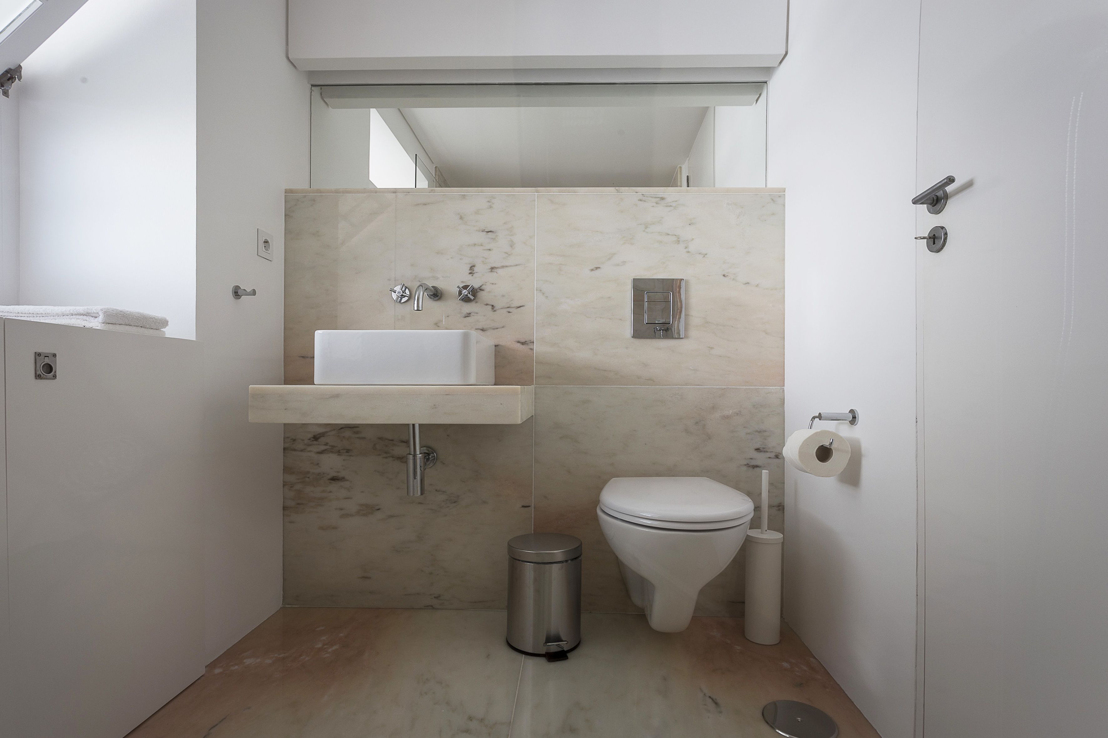 A compact bathroom with a sink, toilet, and shower.