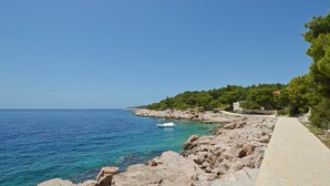 Un sendero costero con terreno rocoso y una vista despejada del mar.