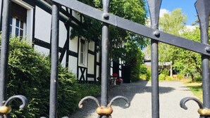 A traditional half-timbered house with a gravel path leading to the entrance. - Musikhaus Medebach. This historic house is in the village in Hochsauerland. (Medebach)