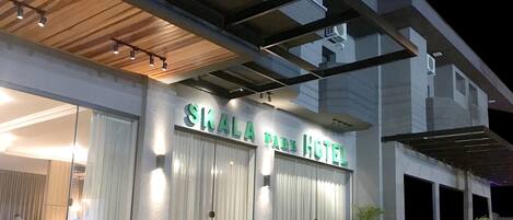 The exterior of the Skala Park Hotel with a modern design, featuring a prominent sign and a covered entrance.