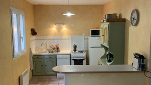 A compact kitchen with a central island, a microwave, a stove, and a refrigerator. - Charming Provencal House - Private Pool - Near Lake & Beaches (Montauroux)