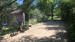 A dirt path leading to a small building with a tiled roof, surrounded by greenery and trees. - Charming Provencal House - Private Pool - Near Lake & Beaches (Montauroux)
