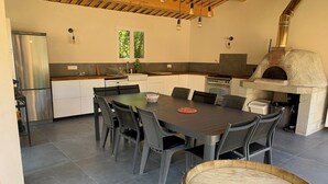 A modern kitchen with a dining area, a built-in oven, and a large window. - Charming Provencal House - Private Pool - Near Lake & Beaches (Montauroux)