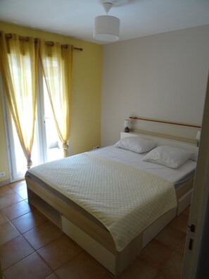 A bedroom with a bed, curtains, a bedside table, and a ceiling fan. - Charming Provencal House - Private Pool - Near Lake & Beaches (Montauroux)
