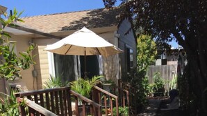 A residential outdoor area with a wooden staircase, potted plants, and a covered seating area. - Easy Bay Hidden Gem (Richmond)