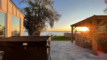 Relax on the patio with a hot tub overlooking the water.