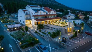 A hotel with a reception area, multiple floors, and a parking lot. - Hotel Vicko (Starigrad)