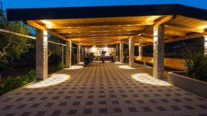 A covered outdoor area with a checkered tile floor, wooden beams, and a central information board. - Hotel Vicko (Starigrad)