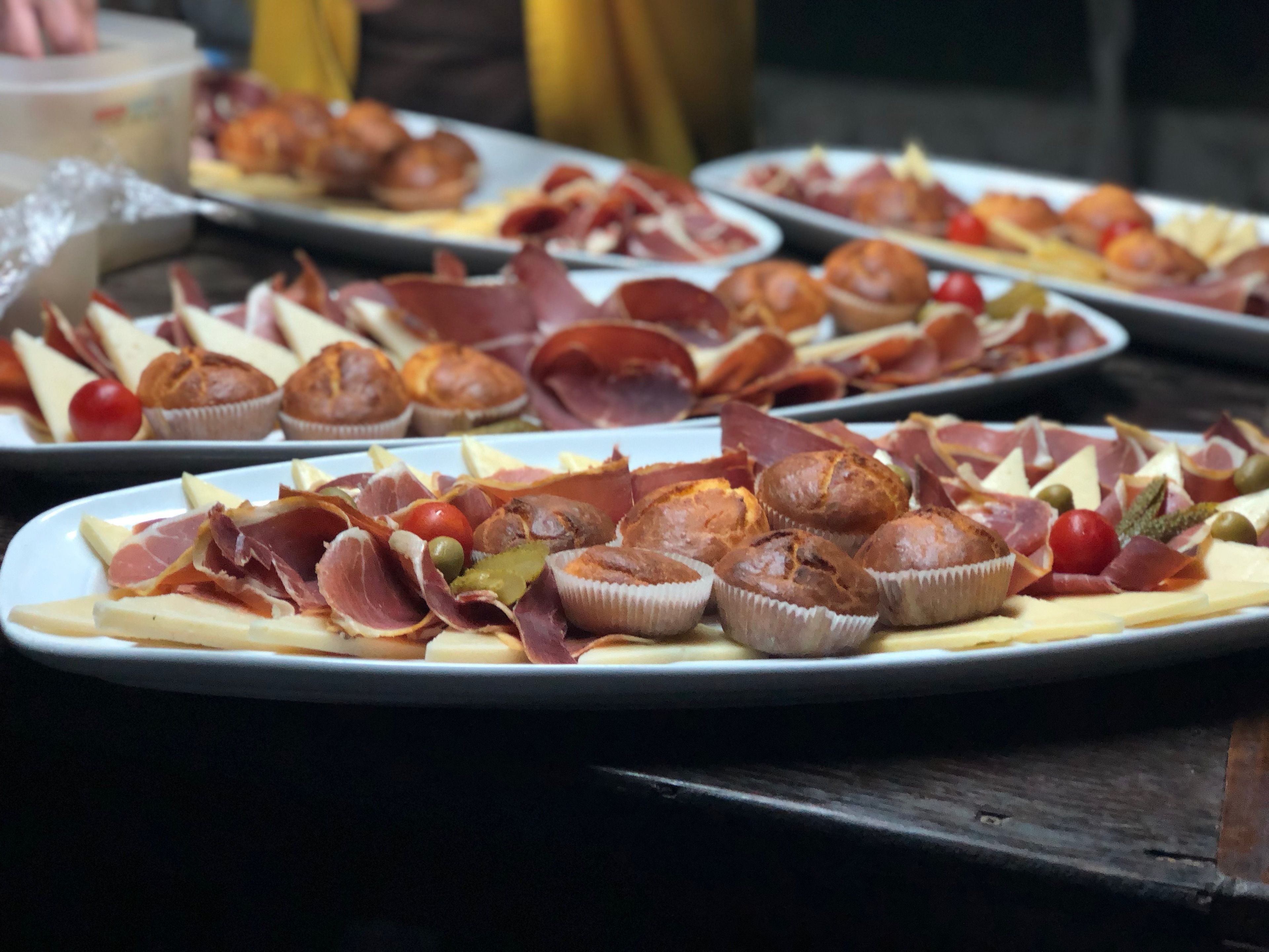 Una mesa con varios platos de comida, incluyendo pasteles y diferentes carnes.