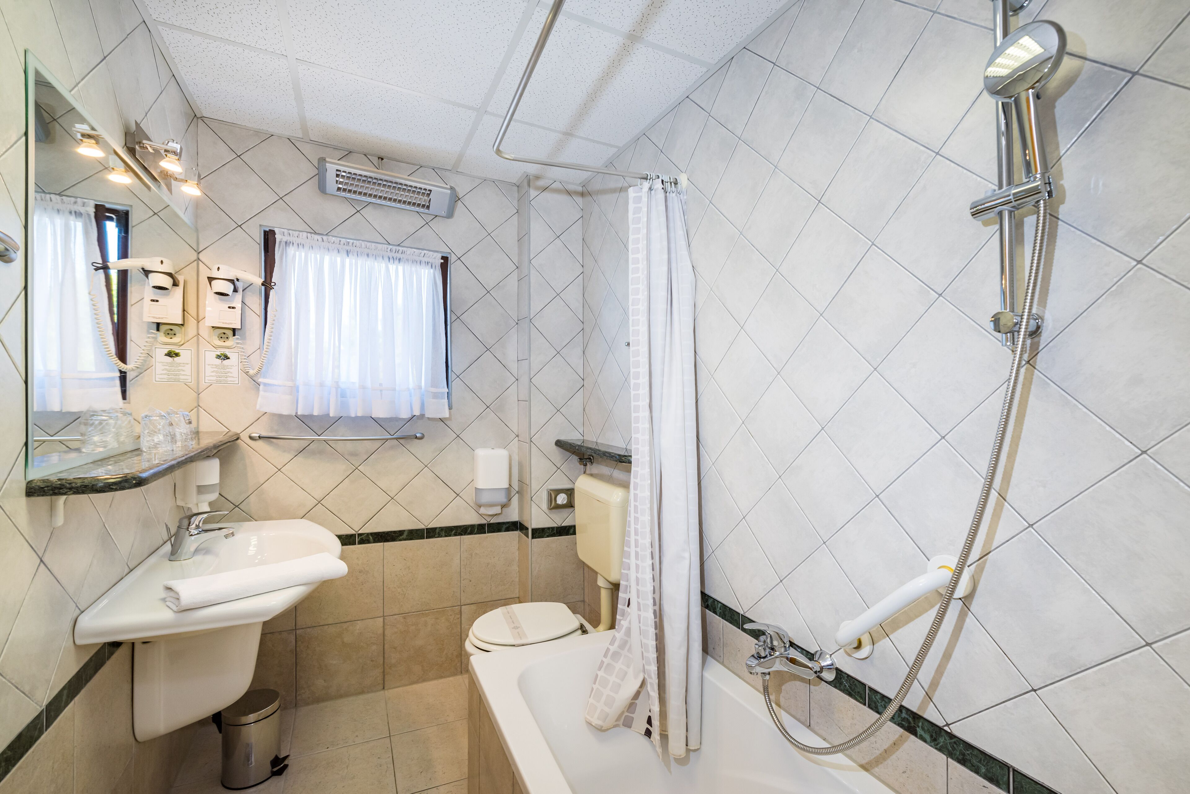 A bathroom with a sink, toilet, and shower.