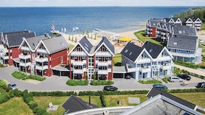 A coastal residential area with multi-story houses featuring balconies and a beach in the background. - 1 bedroom stunning apartment in Rechlin (Rechlin)