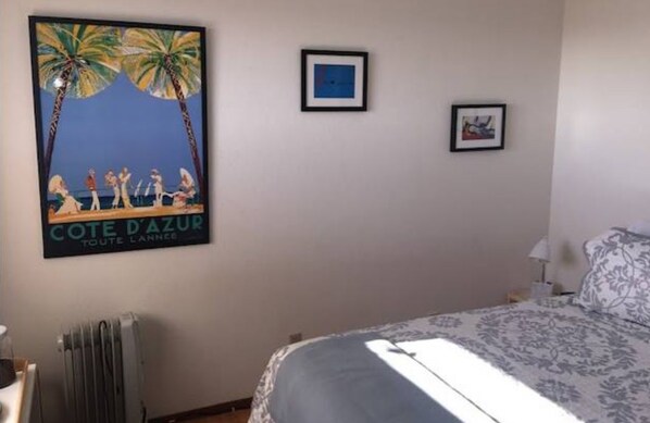 Un dormitorio con una cama, un radiador y un cartel en la pared.