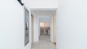 A narrow hallway with white walls and a tiled floor leading to a room with a window and curtains. - JOSIP 1, 3 bedroom apartment, 230m from beach  (Okrug Gornji)