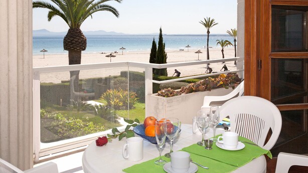 Ein Tisch für zwei mit Blick auf einen Strand und Palmen.