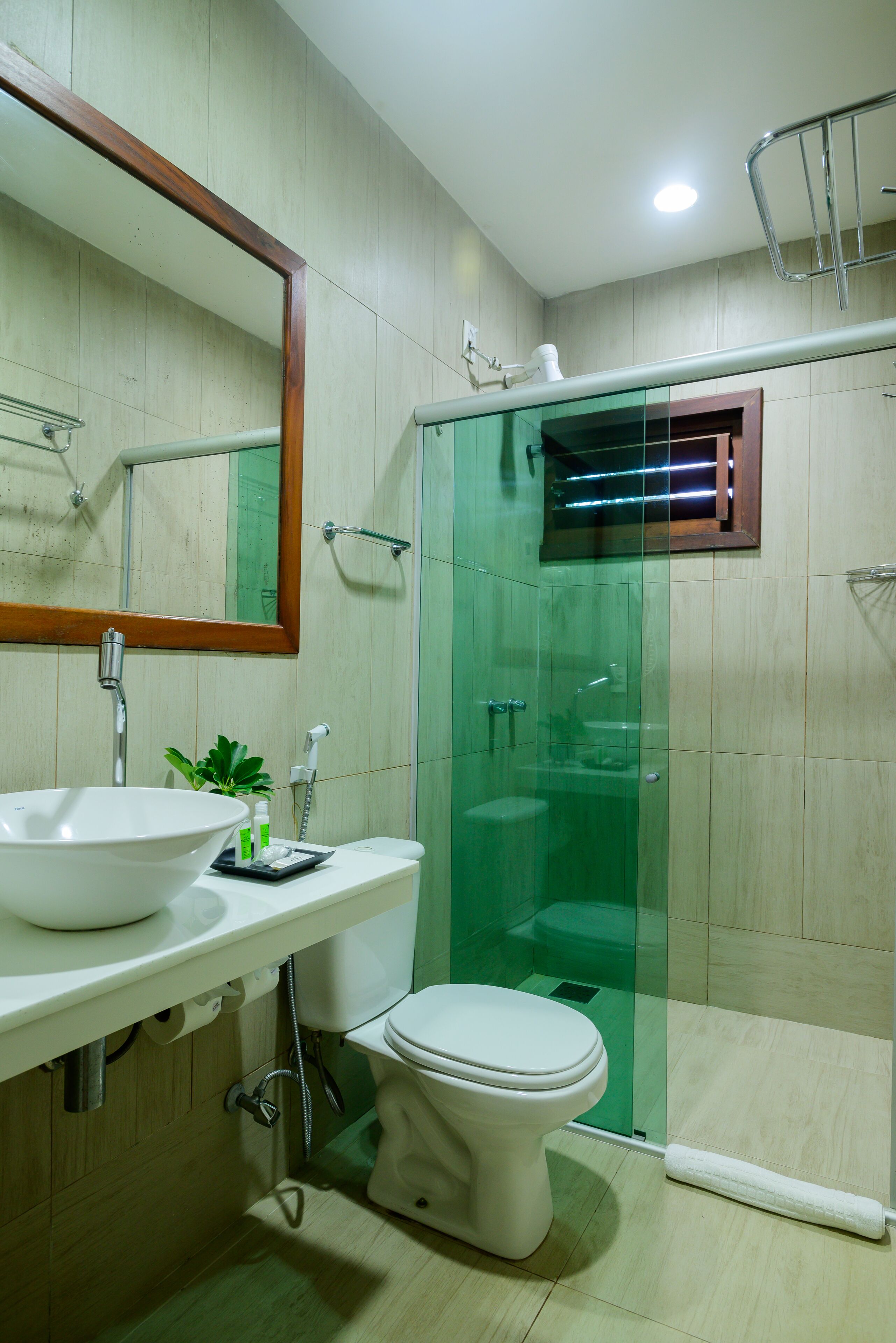 A modern bathroom with a glass-enclosed shower, a white sink, and a toilet.