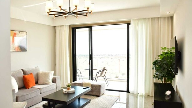 Ein modernes Wohnzimmer mit Sofa, Couchtisch und einem großen Fenster mit Blick.