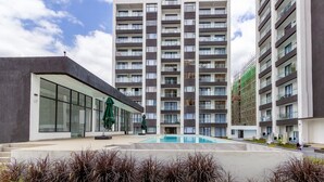 Ein modernes Hochhaus mit einem Pool im Innenhof.