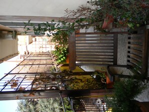 Experience a unique blend of natural and industrial elements in this inviting space, featuring wooden slats, potted plants, and a metal mesh accent.