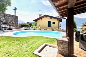 Ein Haus mit Swimmingpool, Steinmauer und Bergblick.