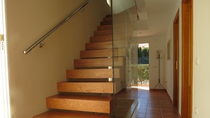 Eine Holztreppe mit Glastrennläufen zu einer Tür.