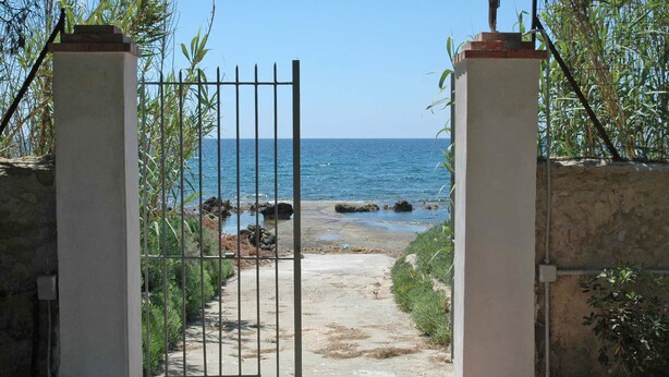 A gated pathway leading to a beach with a clear view of the sea. - Villa in dream location with private pool right by the sea (Siracusa)