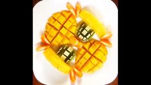 A white plate with neatly arranged mango slices and kiwi pieces. - Come sail the Caribbean Sea aboard Antillean  (St thomas)