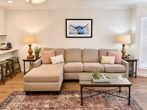 Ein Wohnzimmer mit einer Sofagarnitur, einem Couchtisch und zwei Lampen.